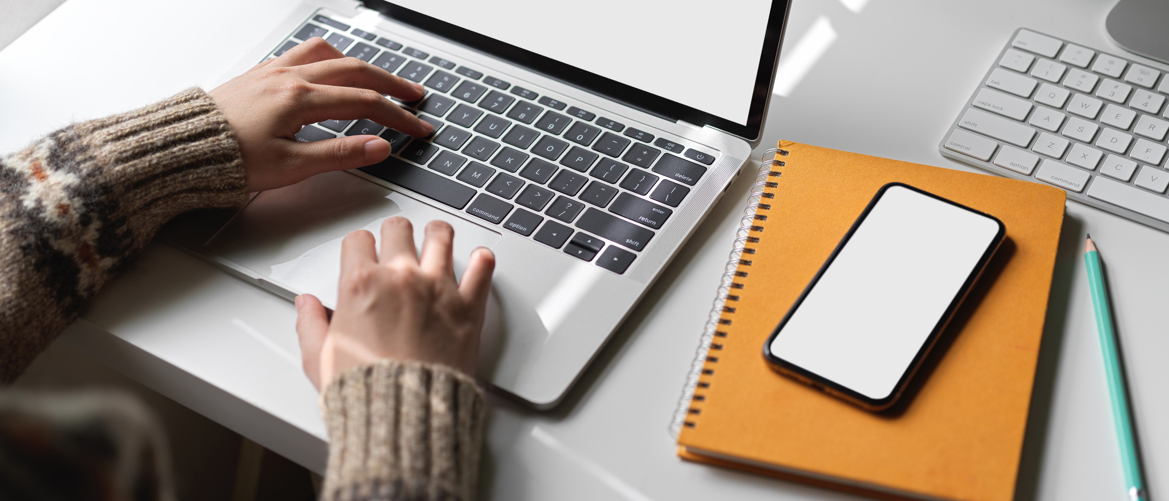 Female university student doing thesis with mock-up laptop, smartphone and stationery on white worktable